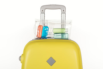 travel bag with cosmetic bag with colorful bottles with liquids isolated on white