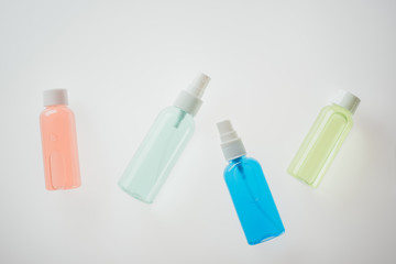 top view of colorful bottles with liquids on white background