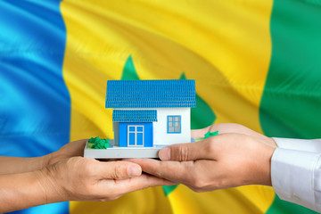 Saint Vincent And The Grenadines real estate concept. Man and woman holding miniature house in...