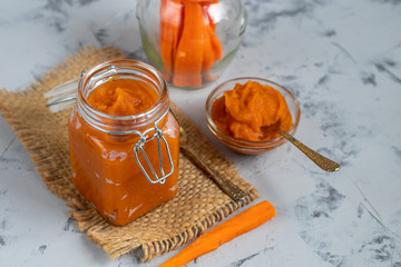 Carrot jam with orange juice, decorated with mint and slices of lemon on a pineapple, stone background. Autumn product. The horizontal location. Copy space. Flat lay. 