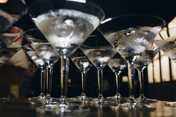 cocktail glasses with ice. the bartender cools the glasses before making cocktails.