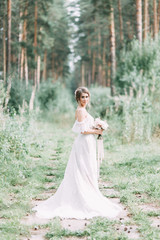 Elegant ceremony in European style. Beautiful bride in white flying dress in the forest.