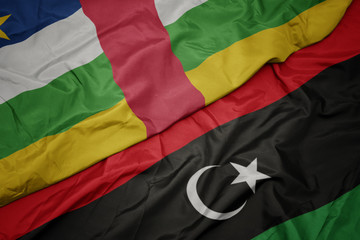 waving colorful flag of libya and national flag of central african republic.