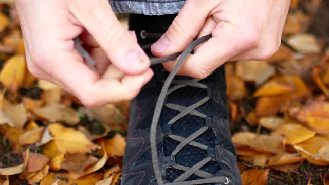 A man laces his shoes. Tie shoelaces on shoes