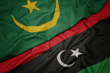 waving colorful flag of libya and national flag of mauritania.