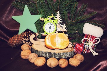 Spruce branches, cones and tangerines with nuts on the background