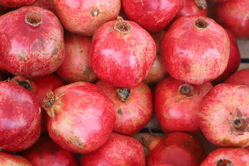 Fototapeta na wymiar closeup of red pomegranates on display at the market