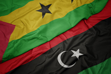 waving colorful flag of libya and national flag of sao tome and principe .