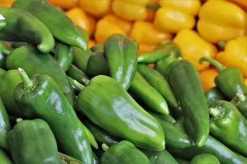 closeup of yellow and green peppers on display at the market