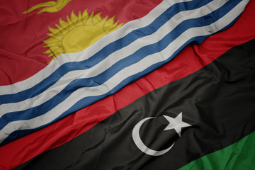 waving colorful flag of libya and national flag of Kiribati .