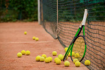 Tennis rackets and plenty of balls on the ground