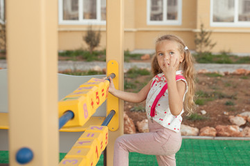 Pretty little girl learn to count, preschooler in kindergarten at the playground