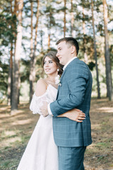 Stylish European wedding at sunset. Happy couple in the forest in nature.