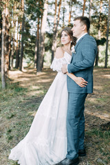 Stylish European wedding at sunset. Happy couple in the forest in nature.