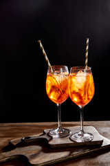 Aperol Spritz in glasses with straws on chopping boards
