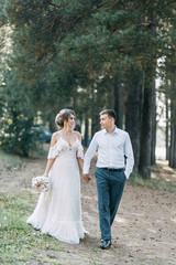 Stylish European wedding at sunset. Happy couple in the forest in nature.
