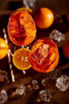 Naklejki top view of Aperol Spritz in glasses, oranges and ice cubes