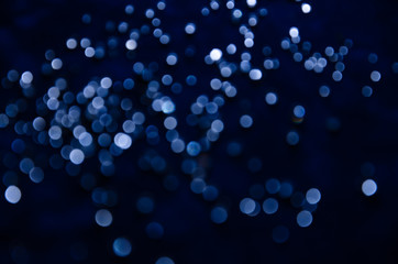 Abstract pattern of blue bokeh garland lights on a dark background