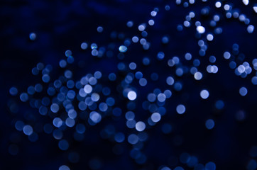 Abstract pattern of blue bokeh garland lights on a dark background