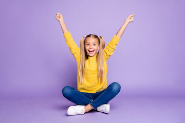 Full body photo of amazed kid sit legs crossed folded win competition raise fists scream wear stylish outfit isolated over purple color background