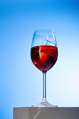 cocktail Aperol Spritz with ice cubes in glass on blue background