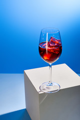 cocktail Aperol Spritz with ice cubes in glass on blue background