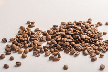 Coffee beans close up scattered on a light background