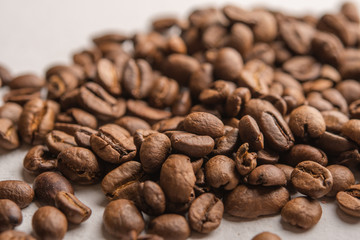 Coffee beans close up scattered on a light background