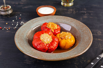 Colorful stuffed peppers with rice and minced meat on wooden background.