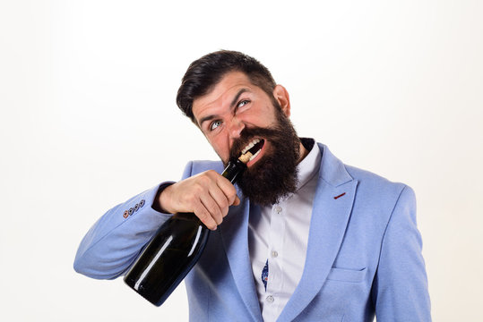 Bearded Man Trying To Open Bottle Of Wine. Bad Habits. Sexy Male Model Pulls Out Cork With Teeth With Bottle Of Wine. Brutal Handsome Man Opens His Teeth Bottle Of Champagne. Champagne Or Wine Bottle.