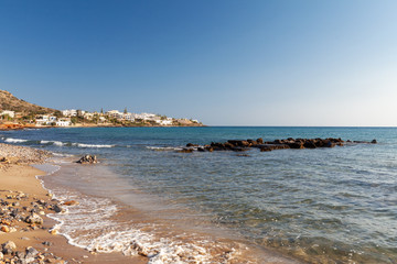 Fototapeta na wymiar view of the beach with sea and blue sky, Crete, houses on the horizon