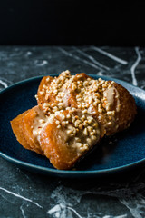 Turkish Dessert Hayrabolu with Sherbet, Tahin, Cheese and Hazelnut Powder.