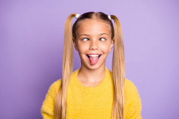 Photo of cheerful funny ridiculous girl sticking her toungue out making eyes look at each other...