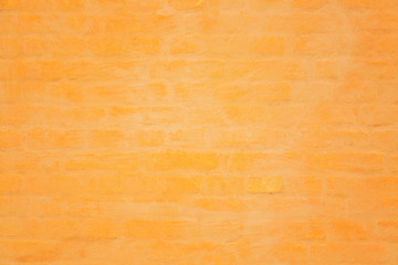 Obraz premium Vibrant yellow or orange brick wall texture background. Abstract architecture detail background.