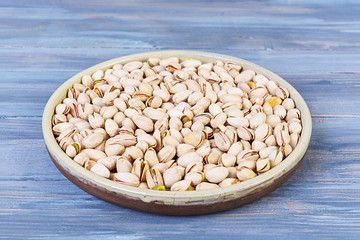 Pistachio nuts on wooden background. Roasted salted pistachios.