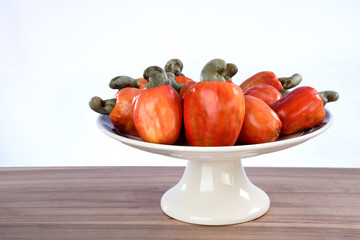 Cashew nuts isolated with glass of fruit juice on white background.