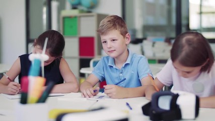 Group of small school kids in class, drawing.