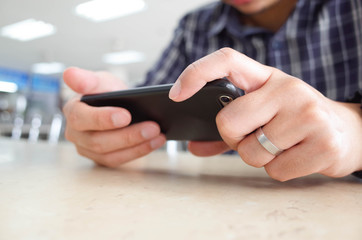 Men hands using smartphone at cafe. man typing an message.