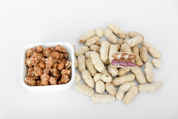 Peanuts and sugar-coated peanuts on a white background