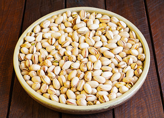 Pistachio nuts on wooden background. Roasted salted pistachios.