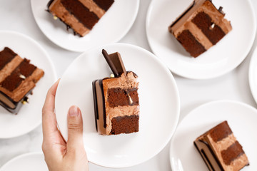 Pieces of layered dark chocolate cake on white plate