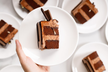 Pieces of layered dark chocolate cake on white plate