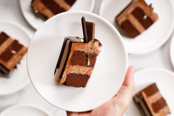 Pieces of layered dark chocolate cake on white plate