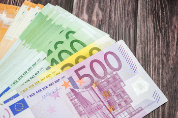 many euro banknotes on wooden background