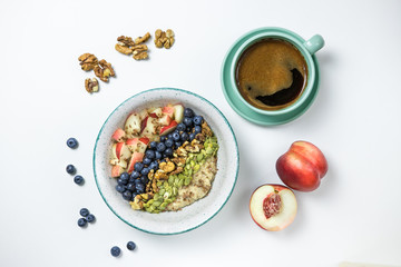 oatmeal breakfast with blueberries and peach and a cup of coffee
