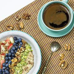 oatmeal breakfast with blueberries and peach and a cup of coffee