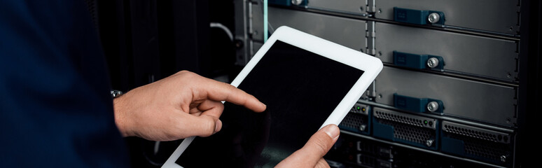 panoramic shot of man pointing with finger at digital tablet with blank screen