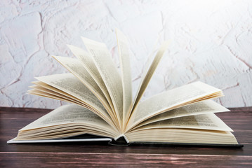 open book on a wooden table. Toned. Side view.