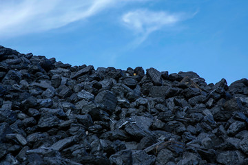 heap of coal against blue sky