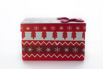 Christmas box with red gifts on white isolated background with the image of Christmas trees located sideways. There is a bow in the corner